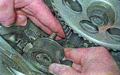 3. Снимаем ролик со шпильки, удерживая ремень в…