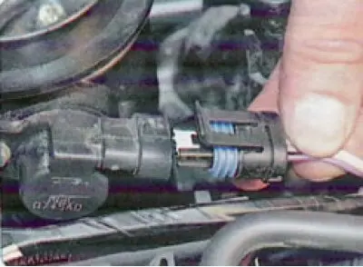 7. After pressing the clamps, disconnect the fuel injector wiring connectors...
