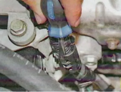 19. Using a screwdriver, disconnect the upper holders of the engine wiring harness at the front...