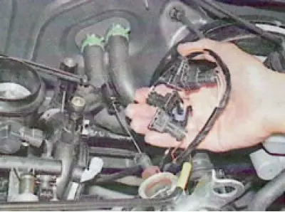 23. Remove the harness from the middle upper holder on the intake pipe...