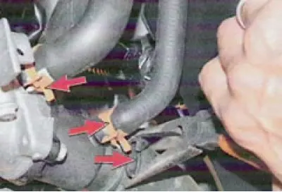 29. Squeeze the fastening clamps and disconnect the hose from the intake pipe to the brake booster.