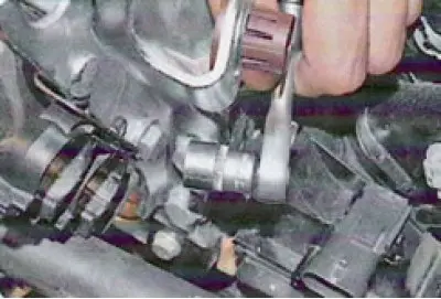32. Remove the heater hoses from the holders on the bracket.