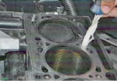 20. Check the cylinder head for warping. Place a metal ruler with its edge on the surface of the…