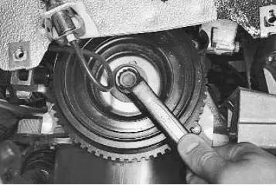 7. Use a 17 mm open-end wrench to unscrew the crankshaft pulley mounting bolt…