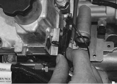 3. Using your fingers to squeeze the latches, disconnect the ignition coil wiring harness…