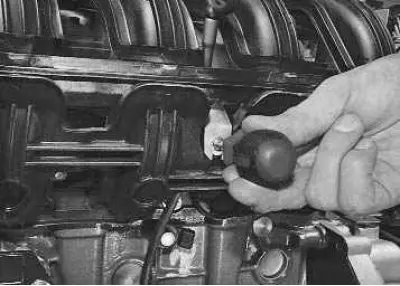 11. Remove the screw securing the oil level indicator (dipstick) guide bracket…