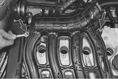 13. Using a 10 mm spanner, unscrew the two nuts securing the intake manifold to the cylinder head…
