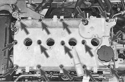 16. Using an 8 mm socket wrench, unscrew the fifteen cylinder head cover mounting bolts...