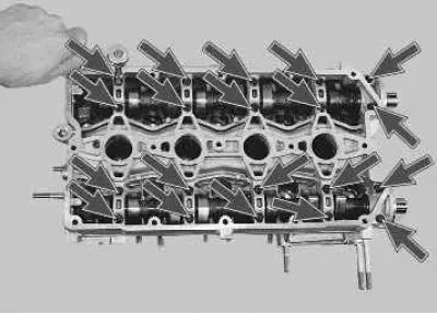 9. Using an 8 mm socket head, unscrew the twenty bolts securing the camshaft bearing housing...
