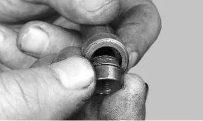 18. Dip the valve stem seal into engine oil and insert it into the mandrel.
