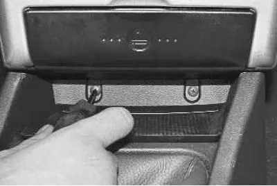 15. Remove the two screws securing the upper floor tunnel trim to the instrument panel.
