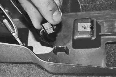 24. …and remove the wiring harness holder from the lower trim.