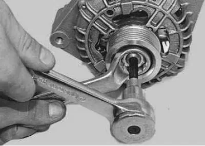 17. Place the open-end wrench on the nut and insert the Allen key through its hole into the shaft…