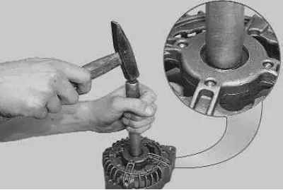 24. Using an aluminum spacer, lightly tap the bearing out of the generator cover with a hammer.
